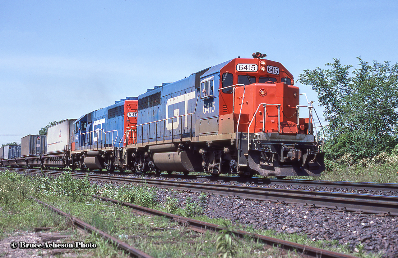 CN/GTW Trailer On Flat Car aka "Laser" train 238 is eastbound along the Oakville Sub approaching Lemonville Road, bound for Brampton Intermodal Terminal. Power today includes a trio of former Detroit Toledo & Ironton GP40-2 locomotives, renumbered into the Grand Trunk Western 6400-series after the DT&I came under GTW control in the early 1980s. 6415/6412 were originally DT&I 415/412.