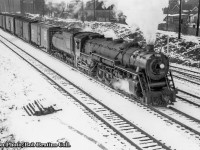 CNR U-3-a 6304 leads an eastbound freight out of Hamilton about to duck under the Emerald Street footbridge.  In the background above the second boxcar, the former Cataract Power Company building can be seen on Victoria Avenue North.  Founded in 1896, the building (built in sections from 1896 – 1907) originally housed a steam boiler, later becoming a hydro substation in 1898 from the Decew Falls Generating Station near St. Catharines.  It would become part of the publicly owned Hamilton Hydro in 1930.  The building has continued to house a number of businesses in recent years, including Hobo Hardware, and Krown Rust Control.  As of August 2020, the building is on it’s way to becoming Evil Empire Studios, a film studio for various artistic works and production companies.<br><br>Originally built by ALCO for the Grand Trunk Western in 1927, 6304, and all twelve U-3-a Northerns  (6300 – 6311) would be transferred to the CNR circa 1941-1942.  It would be scrapped in May 1961.<br><br>More from the Emerald Street footbridge:<br><a href=http://www.railpictures.ca/?attachment_id=32624>May 1967 by Doug Page</a><br><a href=http://www.railpictures.ca/?attachment_id=30908>April 1997 by Arnold Mooney</a><br><a href=http://www.railpictures.ca/?attachment_id=37397>April 2019 by Jamie Knott</a>