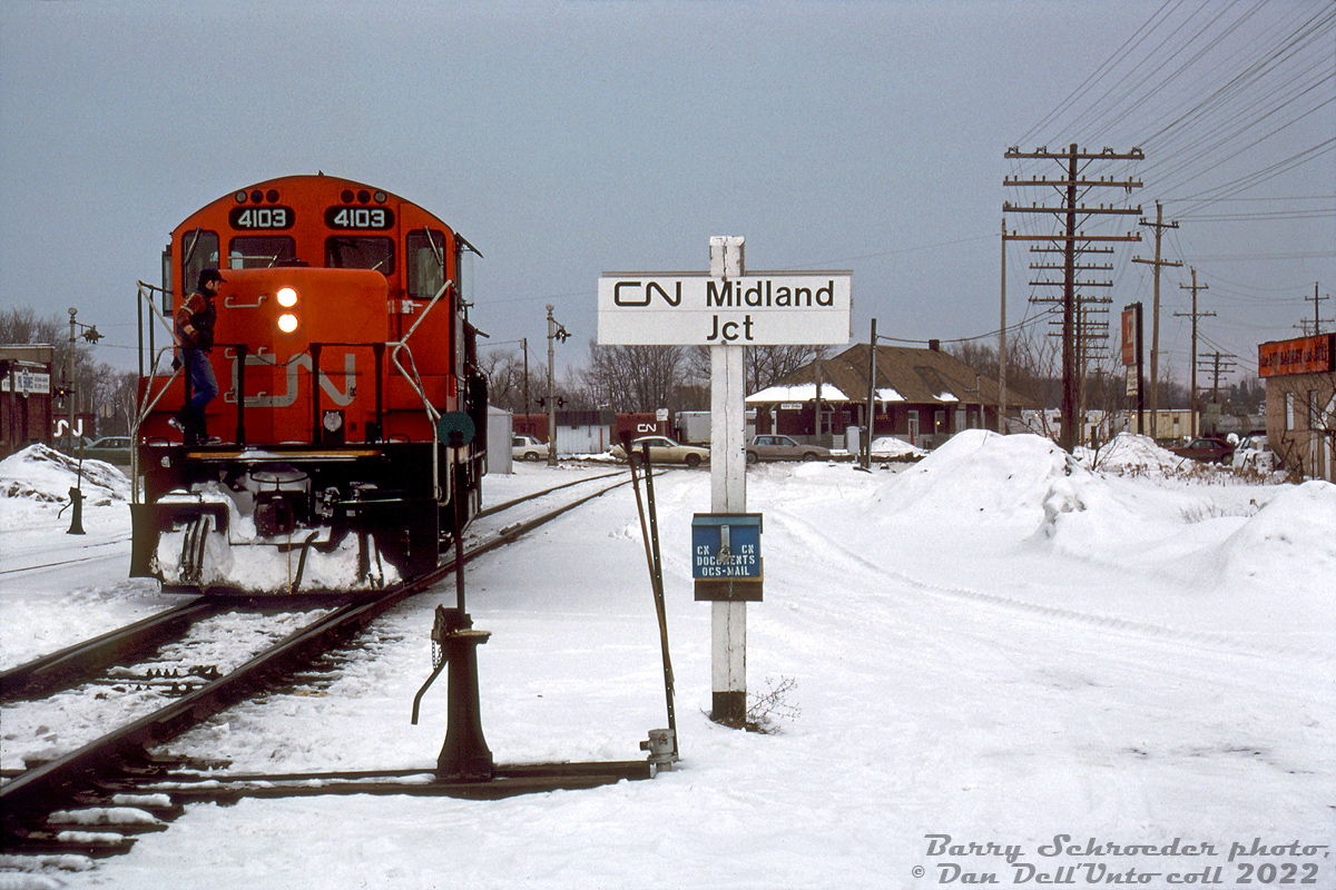 Snowy winter branchline railroading: CN GP9RM 4103 and another unit come off the Midland Sub at Midland Junction in Orillia, entering Mile 86.1 of the Newmarket Sub south of Front Street South crossing. A blue-painted CN billbox is fastened to the station name sign post, with a switch broom at arm's length away to clear out any snowy switch points encountered. VIA/CN's old Orillia Station can be seen in the distance, and behind that some OCS work cars on the other leg of the wye.

Once reaching from Lindsay to Midland, by this time the Midland Sub only ran from Mile 42.7 (Orillia) to 75.2 (Midland), and was one of the many small southern Ontario branchlines on borrowed time. Following dwindling traffic, the line was approved for abandonment in sections during 1994 and 1995 and lifted, followed by CN abandoning the Newmarket Sub north of Barrie (Mile 63) through Orillia to Longford (Mile 93.0) in September 1995, and removing it in 1997-98. Only the Orillia Station, restored in 1989 but recently put up for sale by the city, remains as a reminder of the railway's presence in town.

An abandonment filing noted service on the Midland Sub was provided five days per week from a Barrie-based wayfreight, with traffic mainly being inbound loads of plastics and outbound loads of aggregate from Uhthoff.

Barry Schroeder photo, Dan Dell'Unto collection slide.