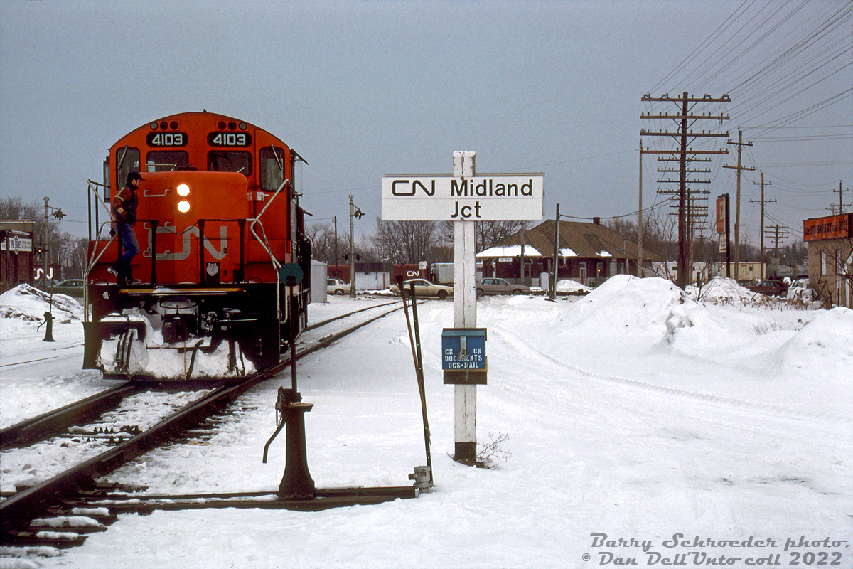 Snowy winter branchline railroading: CN GP9RM 4103 and another unit come off the Midland Sub at Midland Junction in Orillia, entering Mile 86.1 of the Newmarket Sub south of Front Street South crossing. A blue-painted CN billbox is fastened to the station name sign post, with a switch broom at arm's length away to clear out any snowy switch points encountered. VIA/CN's old Orillia Station can be seen in the distance, and behind that some OCS work cars on the other leg of the wye.

Once reaching from Lindsay to Midland, by this time the Midland Sub only ran from Mile 42.7 (Orillia) to 75.2 (Midland), and was one of the many small southern Ontario branchlines on borrowed time. Following dwindling traffic, the line was approved for abandonment in sections during 1994 and 1995 and lifted, followed by CN abandoning the Newmarket Sub north of Barrie (Mile 63) through Orillia to Longford (Mile 93.0) in September 1995, and removing it in 1997-98. Only the Orillia Station, restored in 1989 but recently put up for sale by the city, remains as a reminder of the railway's presence in town.

An abandonment filing noted service on the Midland Sub was provided five days per week from a Barrie-based wayfreight, with traffic mainly being inbound loads of plastics and outbound loads of aggregate from Uhthoff.

Barry Schroeder photo, Dan Dell'Unto collection slide.