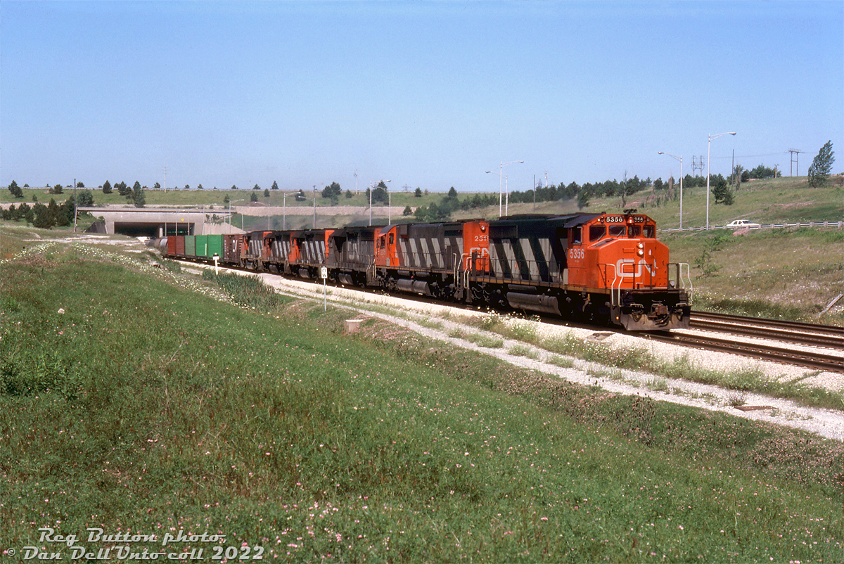 Six high-horsepower road units put their combined 18,600 horsepower to work pulling a rerouted CN #431 out of the Townline Tunnel on the climb out from underneath the Welland Canal. CN SD40-2W 5356, M636 2315, GP40's 9306, 9307, 9308 and GP40-2L(W) 9402 are typical of the mid-80's CN mainline power of the era, of which the widecab units faired best in terms of longevity.

The train is coming out of the tunnel on CN's Cayuga Sub near Brookfield, the other two tracks being CR's former Canada Division (CASO) line (sold to CN & CP two years earlier) and a middle shared track. The line through here, once a part of the busy New York Central corridor through Southern Ontario, today is a shadow of its former self in terms of trains and trackage.

Reg Button photo, Dan Dell'Unto collection slide.