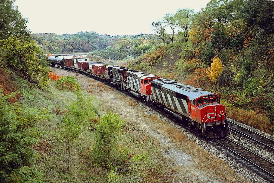 Leading is one of 4 SD60F locomotives manufactured in 1985 but designated as SD50AF when built. The 9900-9903 group was changed to 5500-5503 in 1989 and became the first four of that SD60F series 5500-5563 completed in 1989, now all off the roster. The CN 9902 finished life going to K&K Recycle in 2018.
I had a hard time catching any of these "SD50AF" units.  This image at Bayview Jct as the train starts up the Dundas Sub was shot with the Speed Graphic, 100 ISO colour film at 200 F4.7. Trailing units are 9544 and 9414.