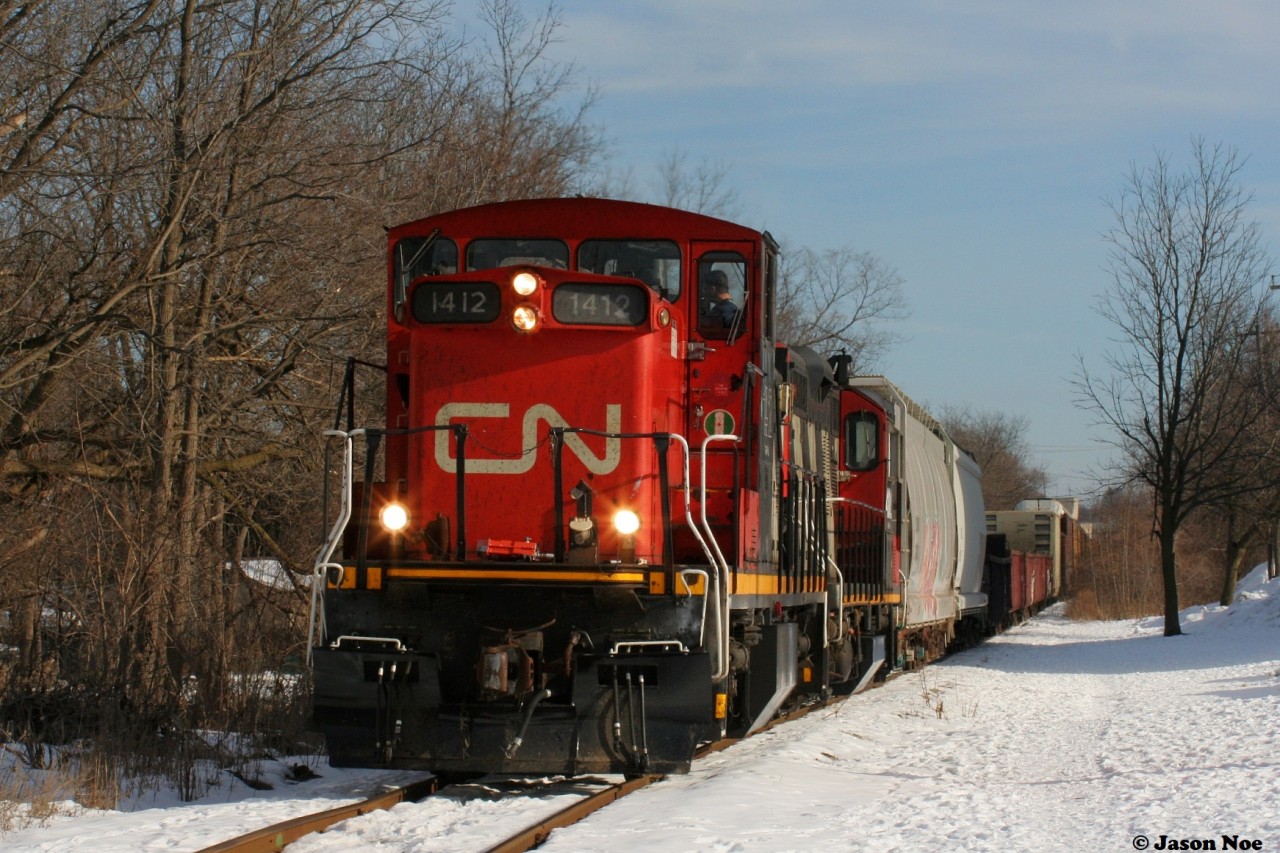 For whatever reason, GMD1's didn't seem to last long once they were assigned to Kitchener. However, during a brief period in early 2021, CN 1412 found its way to Kitchener where it operated on assignments for a short time between January and early February.
While most days during those two winter months were filled with seemingly endless clouds and snow, there were some moments of sun. Luckily 1412 caught one as it and GP9RM 4102 led L540 as they returned from the CP interchange in Kitchener approaching Queen Street on the Huron Park Spur.