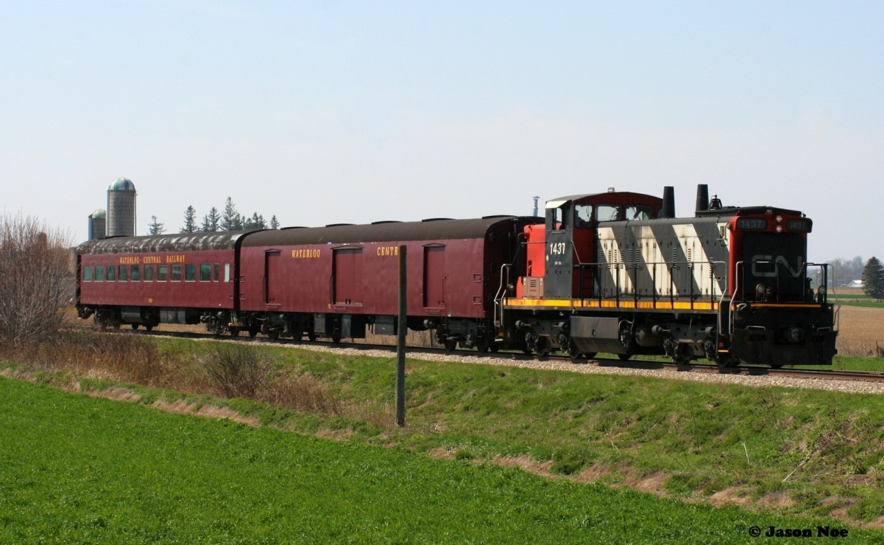 In Mennonite country on a spring morning, GMD1u 1437 shoves towards St. Jacobs with a short passenger train that ever so briefly operated between St. Jacobs and Elmira on the Waterloo Spur. Former CN 1437 was donated to the Waterloo Central Railway (WCR) by CN hours earlier during the night and this was its inaugural journey on the WCR as the crew took it for a quick run.