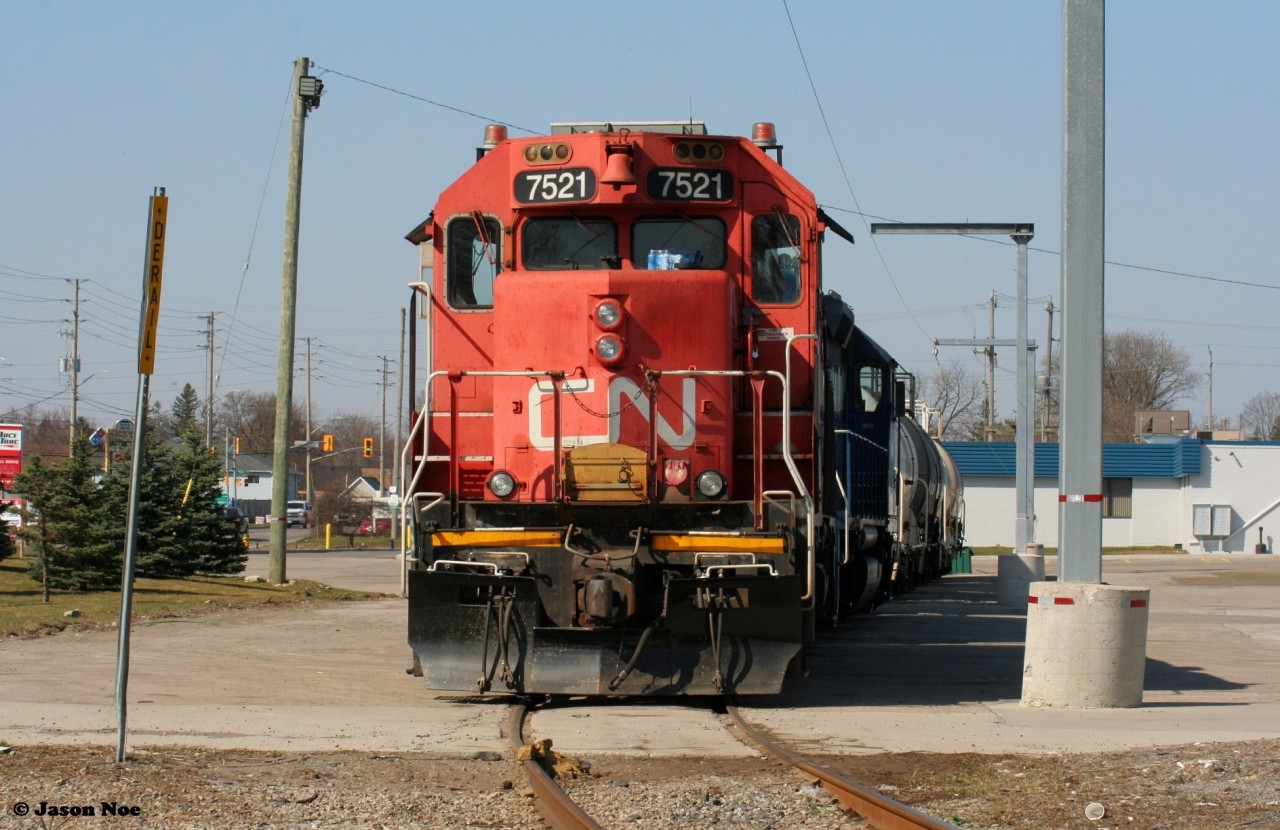 CN L542 power is viewed awaiting its next call to duty along Eagle Street on the Fergus Spur in Cambridge. The power includes former hump unit GP38-2 7521 and GMTX 2695 with tankers lifted from FloChem in Guelph.