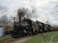 May 1st is the annual anniversary of the famed 1960 CPR Tripleheader from Toronto to Orangeville and back, although this year just a little sadder as at the end of 2021 the line was abandoned and is to be ripped up for a rail trail, parkland, and real estate redevelopment (a fate all too common in decades past).<br><br>From happier days, railfans and their cameras are out and about as CPR 4-4-0 136 and 4-6-0 D10's 815 and 1057 lead their train northbound on the Orangeville Sub through Brampton, crossing Jessie Street in the background. They're about to cross Queen Street (one of the main thoroughfares) and pull up to the old <a href=http://www.railpictures.ca/?attachment_id=43694><b>CPR Brampton Station</b></a> downtown. The switch here south of Queen was for a passing track that ran north to just south of the diamond.<br><br>136 and 1057 survive on the South Simcoe Railway, and the old station was "reconstructed" (rebuilt, expanded, modernized) in the Mount Pleasant area as a community centre, but the old Orangeville/Owen Sound Subdivision from Streetsville to Orangeville (built by the Credit Valley Railway in the 1870's), surviving until recently as the <a href=http://www.railpictures.ca/?attachment_id=35631><b>Orangeville Brampton Railway</b></a>, will soon be relegated to the history books.<br><br><i>Original photographer unknown, Dan Dell'Unto collection slide (with some photo restoration/colour correction done).</i>