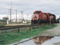 A brief reflection helps to brighten-up an otherwise overcast fall day as CP 141 heads westbound with Control Cab 1117 and GP38-2 3057 through Ayr, Ontario on the Galt Subdivision. 