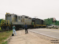 In 1996, CN had officially abandoned their Newmarket Subdivision between Barrie and Longford Mills, severing the mainline as a through route and putting the Canadian on the preferred Bala Subdivision route permanently.  While this section of the line had received extensive attention during its final runs, CN had also deemed the northern section of its Newmarket Subdivision between North Bay and Capreol as no longer required as the only freight traffic on this portion would have been occasional run through trains using the subdivision to reach Capreol. And with trains 450/451 only operating between Toronto and North Bay it was put up for discontinuance. Following its approval of abandonment, CN had contracted emerging company Cando Contracting to remove the heavy mainline rail for them. In the days before internet, cell phones and social media this lengthy operation basically went on virtually undetected and photos are very scarce despite the fact this was still an active mainline until the end. A lot of this had likely to do with the majority of this line being very remote and photo locations not very accessible. 
<br>
So then this is where the expect the unexpected part of the hobby comes into play during one of yearly northern Ontario railfan trips. 
<br>
In late summer 1997, a group of us were heading to Sudbury and decided to detour through North Bay during the morning, hoping to catch something on the Ottawa Valley Railway along the way. That morning, it was very foggy and after some photos at the CP North Bay station we continued our journey on the Trans-Canada Highway towards Sudbury. I believe some of us were even beginning to start nodding-off when a friend suddenly said “Ah buddy there’s GP9’s over there!”  Yup there sure was. Catching us totally off guard were Cando Contracting 1000 and 94 as they slowly appeared between trees , headed to their waiting rail train that was likely situated somewhere in the remote wilderness. At this point the line started paralleling the highway from North Bay within sight so we were able to get ahead of the units and quickly pulled over at the crossing where the Trans-Canada highway intersected it. A mad scramble ensued as camera bags were quickly opened and we all piled out of my dad’s van as we set-up to photographs the units going over the highway. The crossing protection had been previously disconnected so Cando workers had to protect the movement each time a train crossed it. Unfortunately, myself and a friend got in my dad’s photo of the units as they crossed and he likely got one of the best photos of all of us as seen here. The late 90’s were crazy times; where high-hood GP9’s could tear out a mainline virtually unnoticed and then go on to start second careers on  new shortlines the following year. 
