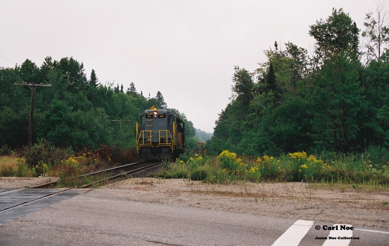 Another view....

In 1996, CN had officially abandoned their Newmarket Subdivision between Barrie and Longford Mills, severing the mainline as a through route and putting the Canadian on the preferred Bala Subdivision route permanently. While this section of the line had received extensive attention during its final runs, CN had also deemed the northern section of its Newmarket Subdivision between North Bay and Capreol as no longer required as the only freight traffic on this portion would have been occasional run through trains using the subdivision to reach Capreol. And with trains 450/451 only operating between Toronto and North Bay it was put up for discontinuance. Following its approval of abandonment, CN had contracted emerging company Cando Contracting to remove the heavy mainline rail for them. In the days before internet, cell phones and social media this lengthy operation basically went on virtually undetected and photos are very scarce despite the fact this was still an active mainline until the end. A lot of this had likely to do with the majority of this line being very remote and photo locations not very accessible.
So then this is where the expect the unexpected part of the hobby comes into play during one of yearly northern Ontario railfan trips.
In late summer 1997, a group of us were heading to Sudbury and decided to detour through North Bay during the morning, hoping to catch something on the Ottawa Valley Railway along the way. That morning, it was very foggy and after some photos at the CP North Bay station we continued our journey on the Trans-Canada Highway towards Sudbury. I believe some of us were even beginning to start nodding-off when a friend suddenly said “Ah buddy there’s GP9’s over there!” Yup there sure was. Catching us totally off guard were Cando Contracting 1000 and 94 as they slowly appeared between trees , headed to their waiting rail train that was likely situated somewhere in the remote wilderness. At this point the line started paralleling the highway from North Bay within sight so we were able to get ahead of the units and quickly pulled over at the crossing where the Trans-Canada highway intersected it. A mad scramble ensued as camera bags were quickly opened and we all piled out of my dad’s van as we set-up to photographs the units going over the highway. The crossing protection had been previously disconnected so Cando workers had to protect the movement each time a train crossed it. Unfortunately, myself and a friend got in my dad’s photo of the units as they crossed and he likely got one of the best photos of all of us as seen here. The late 90’s were crazy times; where high-hood GP9’s could tear out a mainline virtually unnoticed and then go on to start second careers on new shortlines the following year.