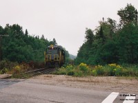 Another view....
<br>
In 1996, CN had officially abandoned their Newmarket Subdivision between Barrie and Longford Mills, severing the mainline as a through route and putting the Canadian on the preferred Bala Subdivision route permanently. While this section of the line had received extensive attention during its final runs, CN had also deemed the northern section of its Newmarket Subdivision between North Bay and Capreol as no longer required as the only freight traffic on this portion would have been occasional run through trains using the subdivision to reach Capreol. And with trains 450/451 only operating between Toronto and North Bay it was put up for discontinuance. Following its approval of abandonment, CN had contracted emerging company Cando Contracting to remove the heavy mainline rail for them. In the days before internet, cell phones and social media this lengthy operation basically went on virtually undetected and photos are very scarce despite the fact this was still an active mainline until the end. A lot of this had likely to do with the majority of this line being very remote and photo locations not very accessible.
So then this is where the expect the unexpected part of the hobby comes into play during one of yearly northern Ontario railfan trips.
In late summer 1997, a group of us were heading to Sudbury and decided to detour through North Bay during the morning, hoping to catch something on the Ottawa Valley Railway along the way. That morning, it was very foggy and after some photos at the CP North Bay station we continued our journey on the Trans-Canada Highway towards Sudbury. I believe some of us were even beginning to start nodding-off when a friend suddenly said “Ah buddy there’s GP9’s over there!” Yup there sure was. Catching us totally off guard were Cando Contracting 1000 and 94 as they slowly appeared between trees , headed to their waiting rail train that was likely situated somewhere in the remote wilderness. At this point the line started paralleling the highway from North Bay within sight so we were able to get ahead of the units and quickly pulled over at the crossing where the Trans-Canada highway intersected it. A mad scramble ensued as camera bags were quickly opened and we all piled out of my dad’s van as we set-up to photographs the units going over the highway. The crossing protection had been previously disconnected so Cando workers had to protect the movement each time a train crossed it. Unfortunately, myself and a friend got in my dad’s photo of the units as they crossed and he likely got one of the best photos of all of us as seen here. The late 90’s were crazy times; where high-hood GP9’s could tear out a mainline virtually unnoticed and then go on to start second careers on new shortlines the following year.