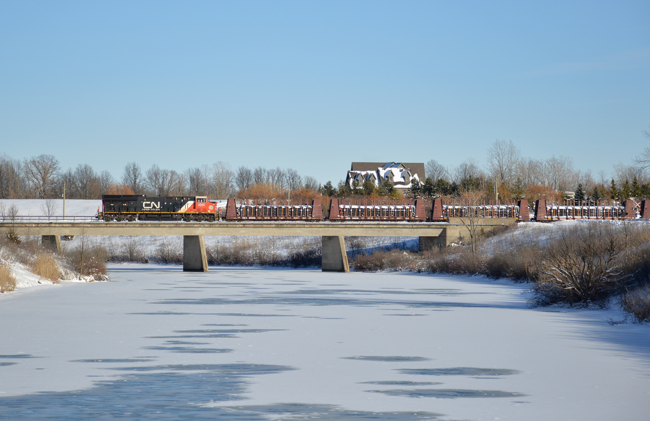 CN GE ET44AC #3262 leads CN L562 long hood forward back towards Port Robinson over the Welland River after interchanging with Trillium Railway at Feeder Yard.