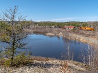 After hearing that the OVR job made quick work in Sudbury and was ready to turn around back to North Bay, I scoured the map for any favourable bend that wouldn't be backlit. Eastbounds in the afternoon, what a joy to shoot! Satellite views showed a clearing here with some elevation across from the tracks, at a spot that also featured a brief stretch of nearly due-south trackage. Score! We decided to try it in the hopes the hillside would be clear enough for a shot. <br>Here, U430 has returned to home rails on the Cartier Sub and skirts a marsh, looking more like a lake with the springtime flows.