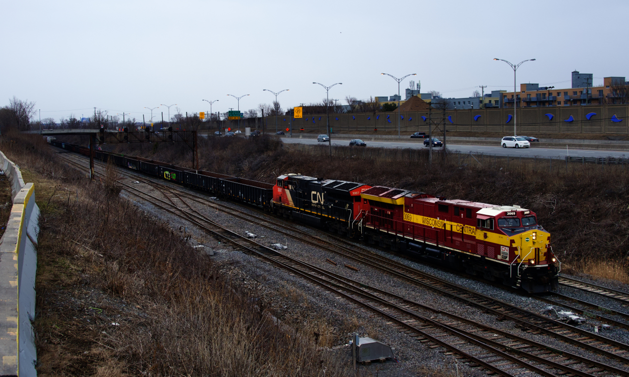 The Wisconsin Central heritage unit has been the hardest one for railfans located in Eastern Canada to shoot as it spent most of its time out west in this current paint scheme. After leading CN 149 out of Montreal in darkness on Saturday morning, I finally got my chance to shoot it for the first time on Sunday, when it came back as DPU on CN 310 and then led CN 321. Here CN 3069 and CN 3067 head west with a short CN 321 on a grey and damp evening.
