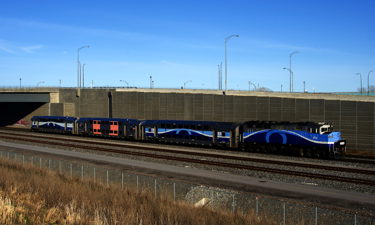 EXO 1211 has one of the few repainted cars in its consist as it heads west with AMT 1345 leading.