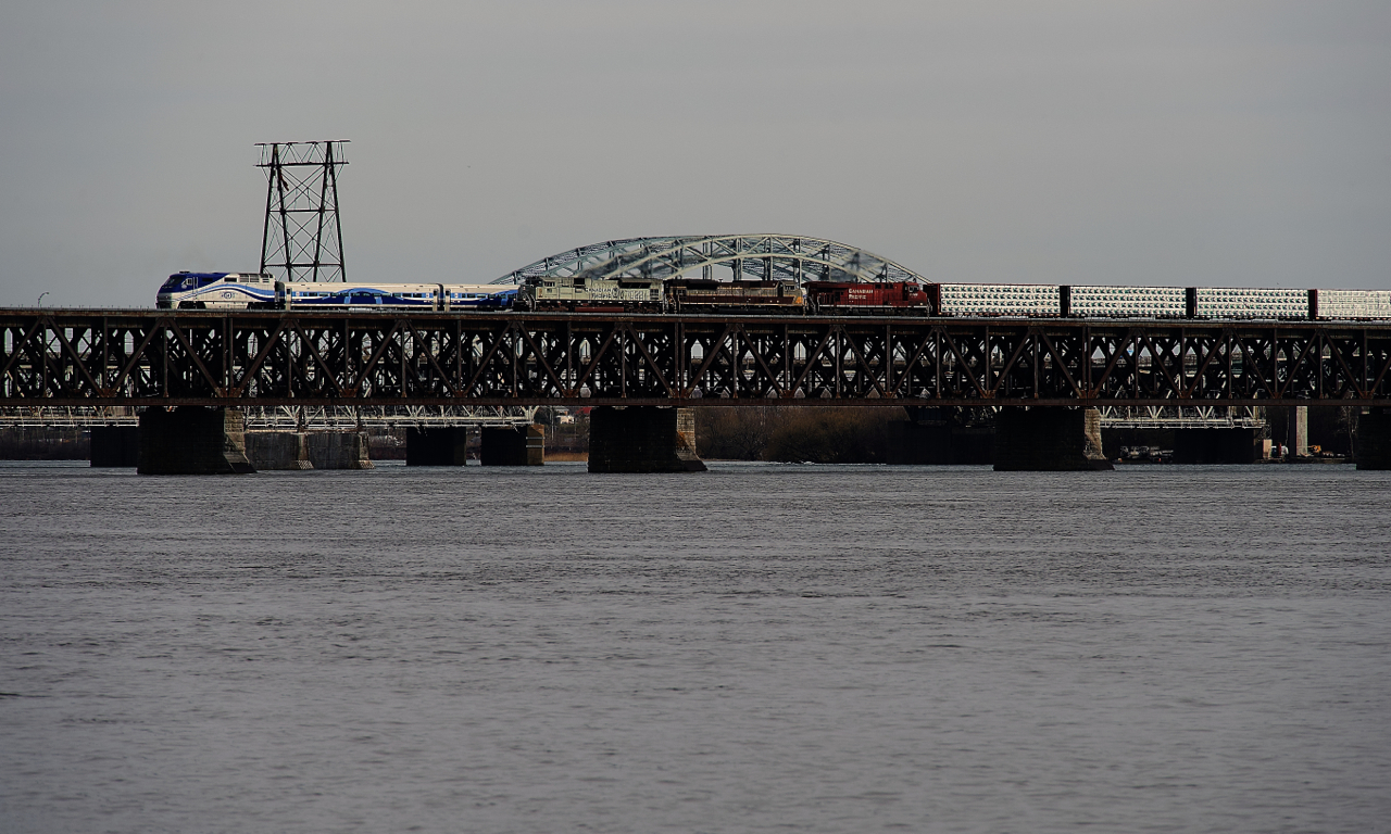 Navy unit CP 7022 is leading CP 223 (formerly CP 251) over the St. Lawrence River as EXO 87 heads in the other direction. Trailing on CP 223 are heritage unit CP 7010 and CP 8749.