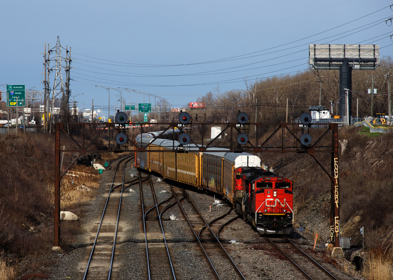 CN X372 with CN 8945 & CN IC 2714 and a train of solid autoracks is crossing over twice as it prepares to leave its train on the transfer track at far right.