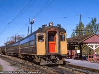 A follow up to an <a href=http://www.railpictures.ca/?attachment_id=47775>earlier posting on these</a> electric operations.<br><br>Canadian National Railway EMU Trailer T4 is now in the lead position waiting to depart Saint Eustache for Gare Centrale in downtown Montreal with a mid-afternoon commuter on a sunny fall day.  Date is approximate, as cars were delivered in 1952 and have a few years worth of wear and tear on them.  Saint Eustache station (formerly Saint Eustache sur le Lac <a href=http://mgvallieres.com/trains/Images/CNStEustacheLac1945a.htm>per a 1945 postcard)</a> would be renamed <a href=http://mgvallieres.com/eust/GareLac/Gare1967.jpg>Deux Montagnes station</a> in 1963, placing this shot about 1960 give or take a few years.  This appears to be a mid-afternoon train, and based on the <a href=https://timetableworld.com/ttw-viewer.php?token=4271d104-ea8e-4c17-bf4d-0ac8ab3ed043>October 1960 CNR timetable,</a> could put it as train 362, departing Saint Eustache at 1330h, or train 364, departing at 1430h.  T4 would later become 6743 during the 1969 repainting and renumbering.<br><br>In an effort to modernize it’s ageing fleet of wooden commuter cars, CNR ordered eighteen Electric Multiple Unit cars in 1952 from Canadian Car & Foundry, six of these being motors numbered M1 – M6, and the other twelve being trailers, numbered T1 – T12.  These would enter service in September 1952, with the motor always leading outbound from Gare Centrale.  Further information can be found in this <a href=https://web.archive.org/web/20160305040336/http://www.exporail.org/can_rail/Canadian%20Rail_no028_1952.pdf>September – October 1952 publication by the CRHA.</a>  The EMU sets would be repainted to CN’s black and grey scheme in 1969 and would be renumbered to the 6700 series along with all other Montreal electric motive power.  The six motors would become 6730 – 6735, and the trailers 6739 – 6749.  Of the eighteen cars, four would not survive to the end of service in 1995.  Motors 6731, 6732 would be destroyed by fires in 1994 and circa 1980 respectively, while trailer 6748 would be scrapped due to corrosion in 1993, and trailer T8 was destroyed in a fatal head on collision in 1960.<br><br>The CN electric era drew to a close on June 2, 1995 with AMT taking over by the end of the year.  Now under the name EXO, the line has been shut down in recent years and all infrastructure removed for rebuilding into the grade separated, driverless REM light rail system.  More on this from Michael Berry <a href=http://www.railpictures.ca/?attachment_id=44393>here (1),</a> <a href=http://www.railpictures.ca/?attachment_id=41330>and here (2),</a> plus an article from Railfan & Railroad <a href=https://railfan.com/montreals-mount-royal-tunnel-closed-for-three-years/>here.</a><br><br>The remaining fourteen cars survive in preservation throughout North America:<br>Motors 6730, 6733, 6735 and trailer 6746 <a href=https://www.oldeenglishdistrict.com/sites/oldeenglishdistrict.com/files/styles/sitewide_default_medium/public/passengersloadingbig.jpg?itok=DvujO9QR>at the South Carolina Railroad Museum in Winnsboro.</a><br>Motor 6734 and <a href=https://www.google.com/url?sa=i&url=https%3A%2F%2Fwww.flickr.com%2Fphotos%2Fkellergraham%2F558095702&psig=AOvVaw1P-FHT_UvKCBmG3yd4UaNp&ust=1648938285487000&source=images&cd=vfe&ved=0CAwQjhxqFwoTCMDb6Pvz8_YCFQAAAAAdAAAAABAD>trailer 6742 at Exporail.</a><br>Trailers 6739, 6743, 6745, 6749 <a href=http://www.trainweb.org/chris/15conway16.JPG>to the Conway Scenic Railroad in North Conway, New Hampshire.</a><br>Trailer 6740 to the <a href=https://i0.wp.com/albertarailwaymuseum.com/wp-content/uploads/2018/11/Passenger-Car-6740-300x165.jpg?ssl=1>Alberta Railway Museum in Edmonton.</a><br>Trailers 6741, 6744, 6747 to <a href=http://www.trainweb.org/oldtimetrains/tourist/APXX_6744.jpg>Alberta Prairie Railway Excursions in Stettler.</a><br><br>More EMU:<br><a href=http://www.railpictures.ca/?attachment_id=45843>6731 at Portal Heights,</a> June 1979 by Peter Jobe<br><a href=http://www.railpictures.ca/?attachment_id=17513>6733 at Val Royal,</a> June 1991 by Glenn Courtney<br><a href=http://www.railpictures.ca/?attachment_id=33147>6734 on display at Exporail,</a> April 2018 by Michael Berry<br><a href=http://www.railpictures.ca/?attachment_id=17598>6743 arriving at Mont Royal,</a> July 1977 by John Eull<br><br><i>Truman Hefner Photo, Jacob Patterson Collection Slide.</i>
