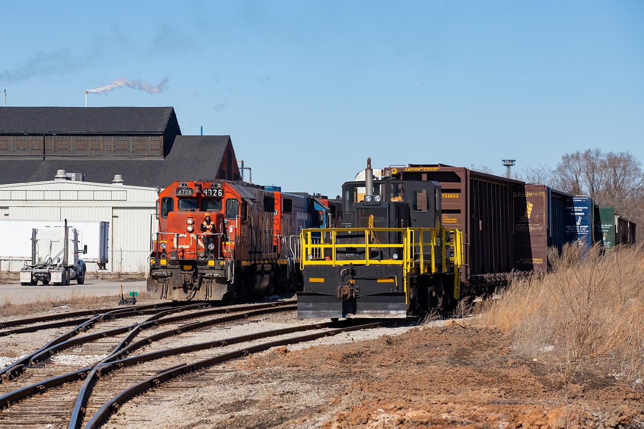 An odd meet to say the least.. the CN 0700 Yard Job emerges from the Railcare facility area while Railcare's 759 grabs some centrebeams for repair.