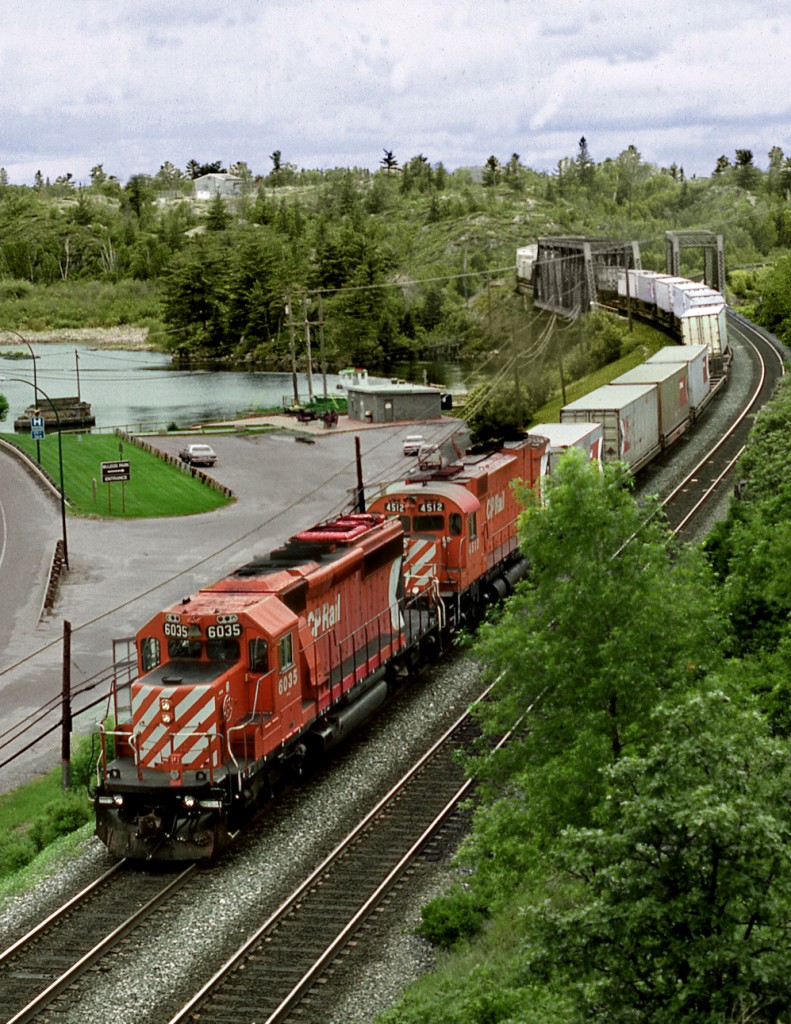 Eastbound time freight 402 has just crossed the east arm of the Winnipeg River at its intake with the Lake of The Woods. The train is approaching the station where a crew change will take place