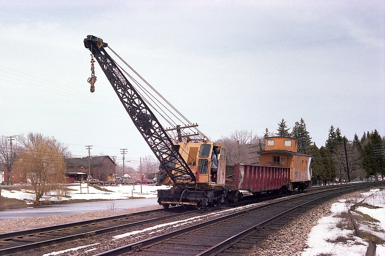 After working just east of the village, CP MoW equipment is returning to Guelph Jct. The large structure to the left of the crane still stands on the corner of Guelph Line & Campbellville Rd.