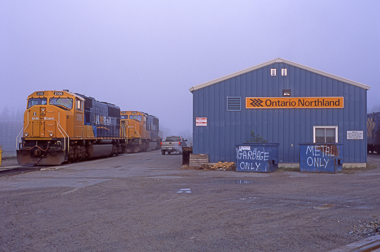 A foggy late September morning in Englehart sees ONT 2105 and 2100 sitting on the shop track.  At the time this was taken the rumours of an impending CN takeover of ONR were quite heavy.  Luckily none came to fruition.
