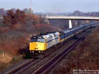 New VIA power? In 1989 that meant more modern HEP-equipped 3000 horsepower F40PH-2D locomotives! At the time a third order of units were being cranked out by GMD London for VIA (6430-6458), and one of which, VIA 6455 (built mid-1989) leads 6423 (from the second order, 6420-6429, built in 1987) on train #73 as they climb the grade at Mile 1 of CN's Dundas Sub passing some of the leftover fall foliage trackside. A steam generator car and 11 of the blue and yellow fleet of ex-CN passenger cars make up the consist, painted to match the old F-unit fleet that VIA ran since startup.
<br><br>
<i>Bill McArthur photo, Dan Dell'Unto collection slide.</i>