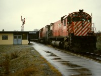 With the regular coal train route to and from Roberts Bank closed (possibly due to work on the bridge at Mission City), this empty eastward train has detoured over BN north from Colebrook and over the Fraser River bridge at New Westminster then up the Westminster sub. on CP to the mainline junction (now Macaulay) half a mile west of this photo taken on Saturday 1972-11-04.  MLWs like 4565 and 4562 were regular coal power in the early years of Roberts Bank trains.  Despite being in the city of Port Coquitlam, CP maintained the station name Coquitlam for many years, with two train order offices, this one “JN” on the main and “YD” in the yard.