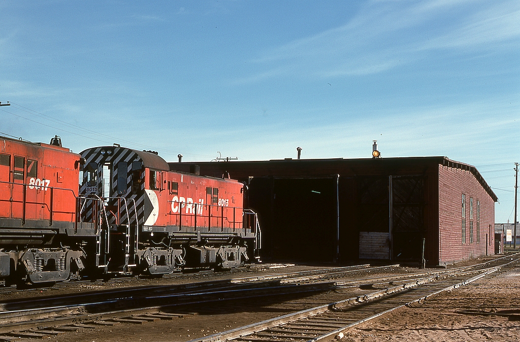 At Prince Albert, CP’s shop facilities were modest compared with CN’s roundhouse off to the south, a simple four-track engineshed, utilized every night in the old way of storing engines inside, even an old reflector-and-bulb headlight for area illumination.  Here, two lightweight RS-23s await their next assignment.  This is all completely history now, very difficult to know a railway yard was even there.