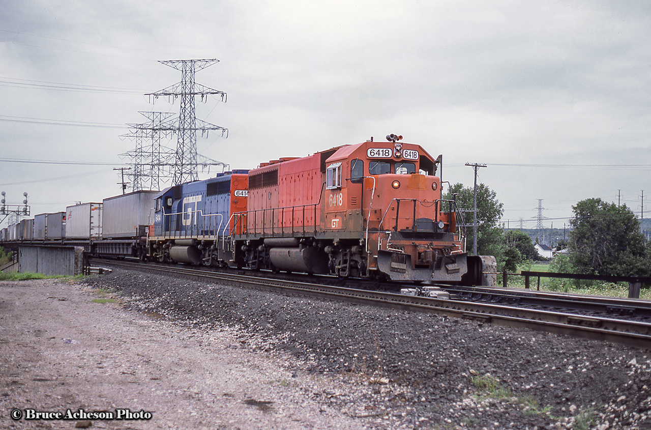 Before and after.  The daily Laser train crosses over Plains Road in Burlington, approaching the junction with the Halton Sub at Burlington West.  Up front is patched GT 6418 wearing it’s old Detroit, Toledo & Ironton colours, while trailing GT 6414 wears the full blue scheme.