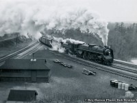 An eastbound freight descends the grade from Copetown behind a CNR Northern, swinging east towards Bayview Junction and onto the Oakville Sub.  Note the double track cowpath at left, single tracked by the time <a href=https://digitalarchive.mcmaster.ca/islandora/object/macrepo%3A73671>this 1953 aerial shot was taken.</a>  Compare this view to <a href=http://www.railpictures.ca/?attachment_id=44864>that of today.</a>  MoW siding gone, as are section sheds.  Track materials still dot the area though.  Though unidentifiable, the Northern in question is a U-2-h class engine, numbered 6235 - 6264, and identifiable with the single large dome atop the centre of the boiler.<br><br><a href=http://www.railpictures.ca/?attachment_id=46407>Click HERE</a> for a 1959 view of a freight taking the cowpath to Hamilton.