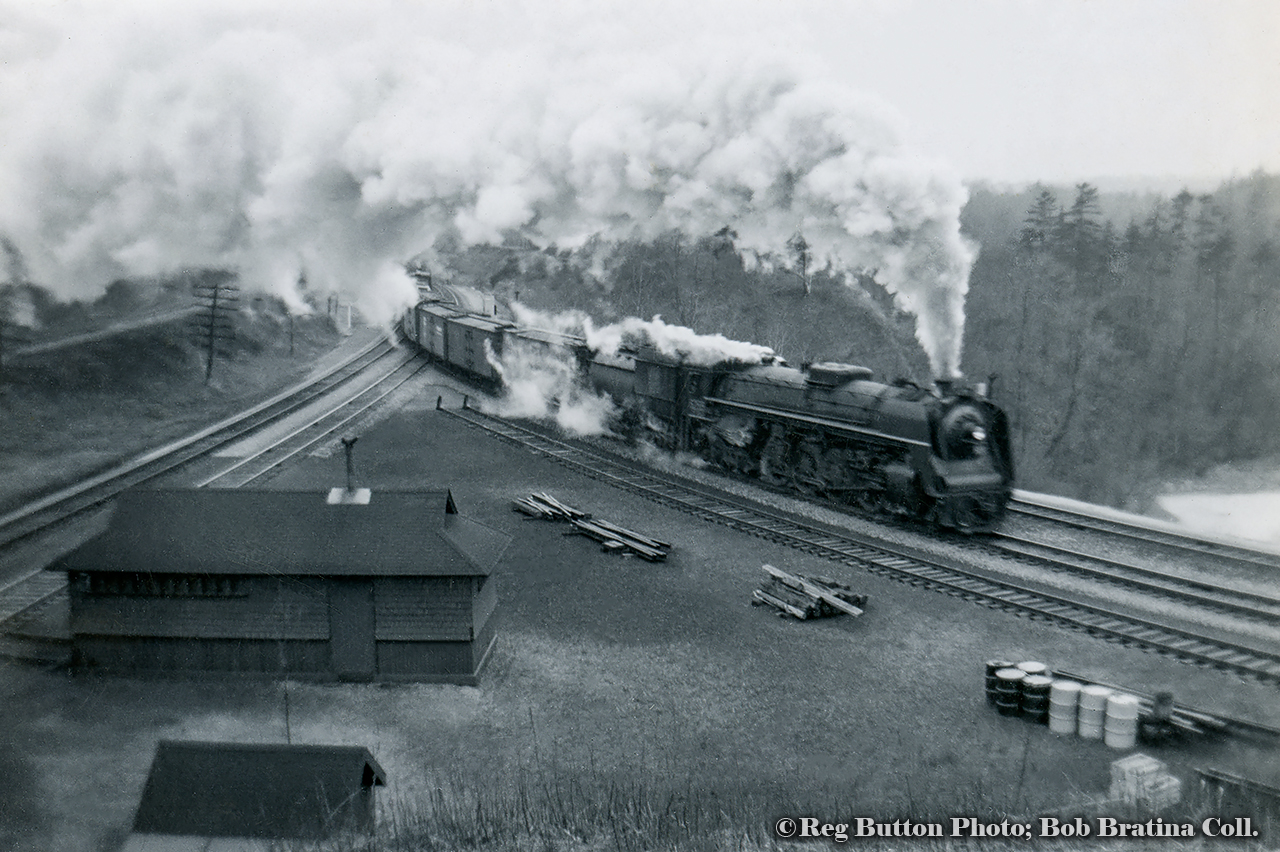 An eastbound freight descends the grade from Copetown behind a CNR Northern, swinging east towards Bayview Junction and onto the Oakville Sub.  Note the double track cowpath at left, single tracked by the time this 1953 aerial shot was taken.  Compare this view to that of today.  MoW siding gone, as are section sheds.  Track materials still dot the area though.  Though unidentifiable, the Northern in question is a U-2-h class engine, numbered 6235 - 6264, and identifiable with the single large dome atop the centre of the boiler.Click HERE for a 1959 view of a freight taking the cowpath to Hamilton.