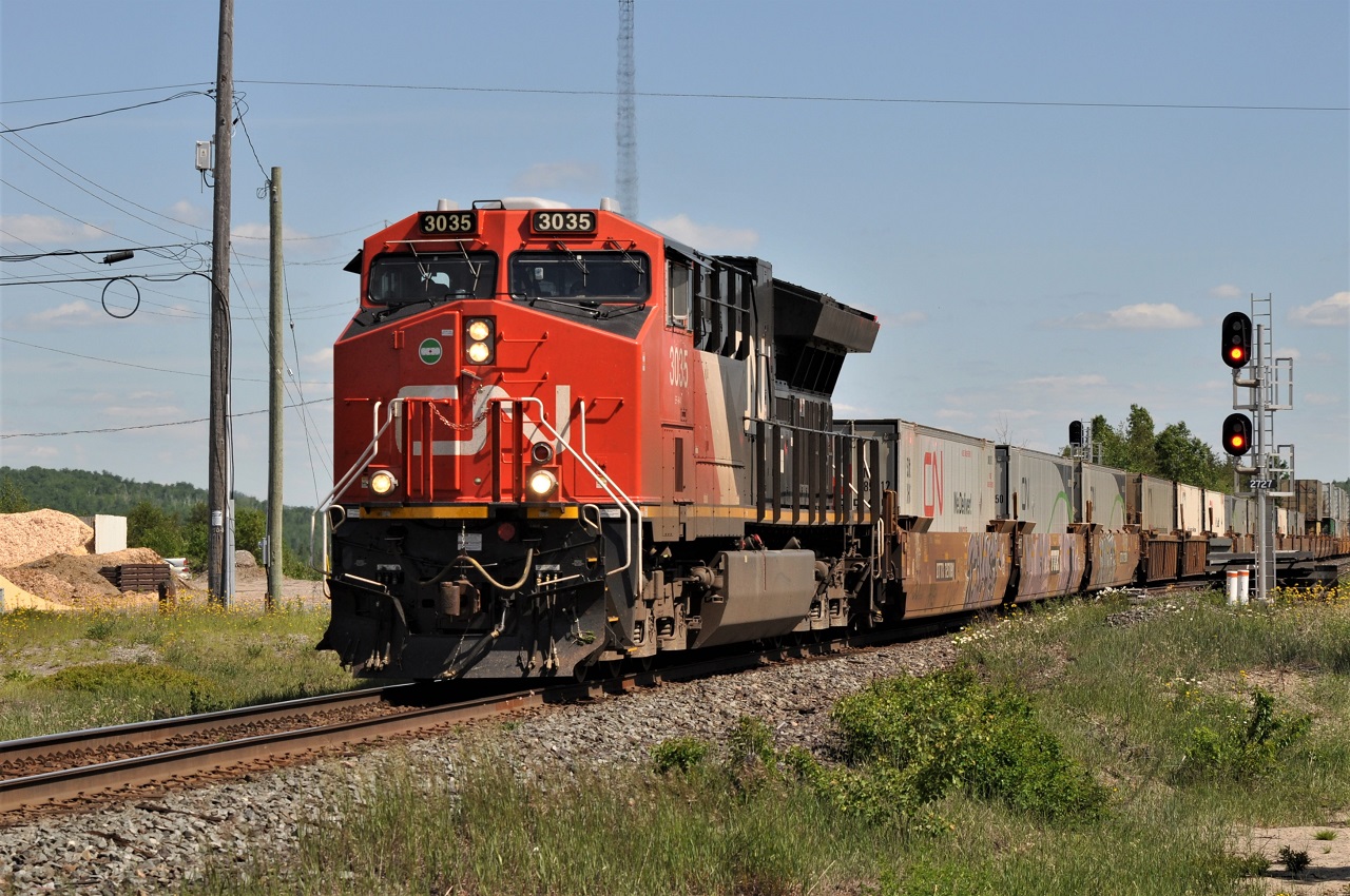 One of CN's many double stack container trains roars over the south switch at Suez, Ontario on June 16, 2016.  DPU CN 2840 brings up the markers of the train.