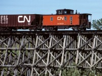 A unit train is passing over the wood trestle at mile 17.7 as it returns to Edmonton at 8:30. The chimney with the top missing, to the right of the cupola, sure looks odd.