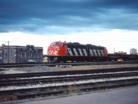 Normally assigned to passenger trains to Thompson and/or Churchill, today two of the F7Au locomotives based in Winnipeg have drawn a work train assignment, probably for the Prairie Branchline Rehabilitation program that was going on at the time (note the side-dump cars). On their way back to Symington, these units are passing the VIA station and CN's Prairie Region offices. In the background, you can see buildings from the East Yard which at one time hosted extensive team track and express facilities and still had VIA's coach in the early 1980s. Today, the area east of the Station is The Forks market.