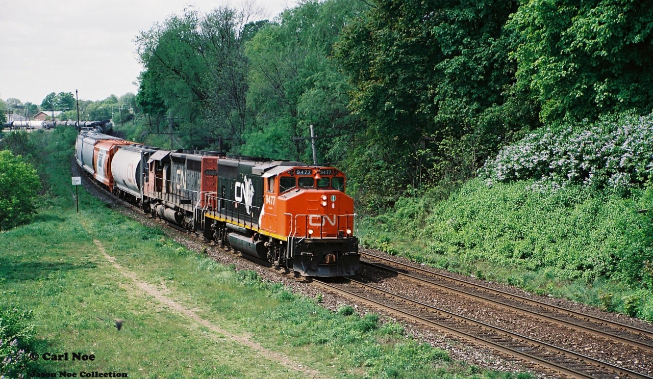 A CN eastbound is viewed curving through the town of Paris approaching the John Street bridge with 9477 and 6020 providing the power on this humid summer day as it heads to Hamilton.