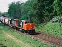 A CN eastbound is viewed curving through the town of Paris approaching the John Street bridge with 9477 and 6020 providing the power on this humid summer day as it heads to Hamilton.