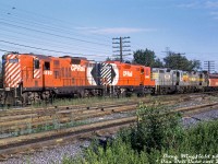 GMD units were typical of the power Canadian Pacific ran in the west during the 1970's, even more so when the CLC power was being retired and MLW's sent to the east. A glance at a CP Power Distribution summary for the Pacific Region shows plenty of GP7's, GP9's, FP7's, B-units, SW1200RS, SD40's and SD40-2's assigned to the maintenance base of Alyth in Calgary (as well as M630's and H16-44's for a time, and some smaller SW900 and S3/S4 switching power). <br><br> Reflecting that is this solid all-GMD consist: GP9 8693, GP7 8409 (part of CP's very first order of GP units, 8409-8411), PNC GP9 130 & GP7 118, and FP7 4062. They're seen at the south end of Alyth Yard by the Bonnybrook / Bow River bridge, possibly a power move waiting to head into the yard to pick up their train. <br><br> The two PNC units were originally built by GMD London for the <a href=http://www.railpictures.ca/?attachment_id=8265><b>Quebec, North Shore & Labrador Railway</b></a> in Quebec. A bunch were sold to newly formed <a href=http://www.railpictures.ca/?attachment_id=43428><b>Bellequip</b></a> to lease to CP around October 1971, and the Bellequip units changed hands to larger US-based Precision National Corp (locomotive rebuilder and leaser) effective February 1972. During their CP tenure the PNC's were split between Alyth and St. Luc for maintenance, and they lasted until the mid-70's traffic downturn that saw them all going off-lease in July 1975. Most were then scooped up by the Chicago & North Western RR in short order, who had embraced a program to acquire and rebuilt many old secondhand Geeps at the time (they were more cost-effective to purchase and rebuild, compared to buying new GP38-2 units from EMD). <br><br> As for the CP power here, all of their serviceable GP7 and GP9 units were rebuilt as <a href=http://www.railpictures.ca/?attachment_id=12954><b>GP7u/GP9u yard and roadswitcher power</b></a> under CP's 10-year motive power plan starting in 1980. The remaining freight F's were retired in the early 80's and scrapped, although some were kept for <a href=http://www.railpictures.ca/?attachment_id=8593><b>Montreal commuter service</b></a> (4070-4075 & 4040, later to <a href=http://www.railpictures.ca/?attachment_id=29750><b>MUCTC/AMT</b></a>) and <a href=http://www.railpictures.ca/?attachment_id=41889><b>Alyth hump power</b></a> (a few 4400-series B-units). Overhauled trucks off retired F-units (done by Ogden) showed up under the first order of new <a href=http://www.railpictures.ca/?attachment_id=25402><b>3000-series GMD GP38-2's</b></a> delivered in 1983. <br><br> <i>Doug Wingfield photo, Dan Dell'Unto collection slide.</i>