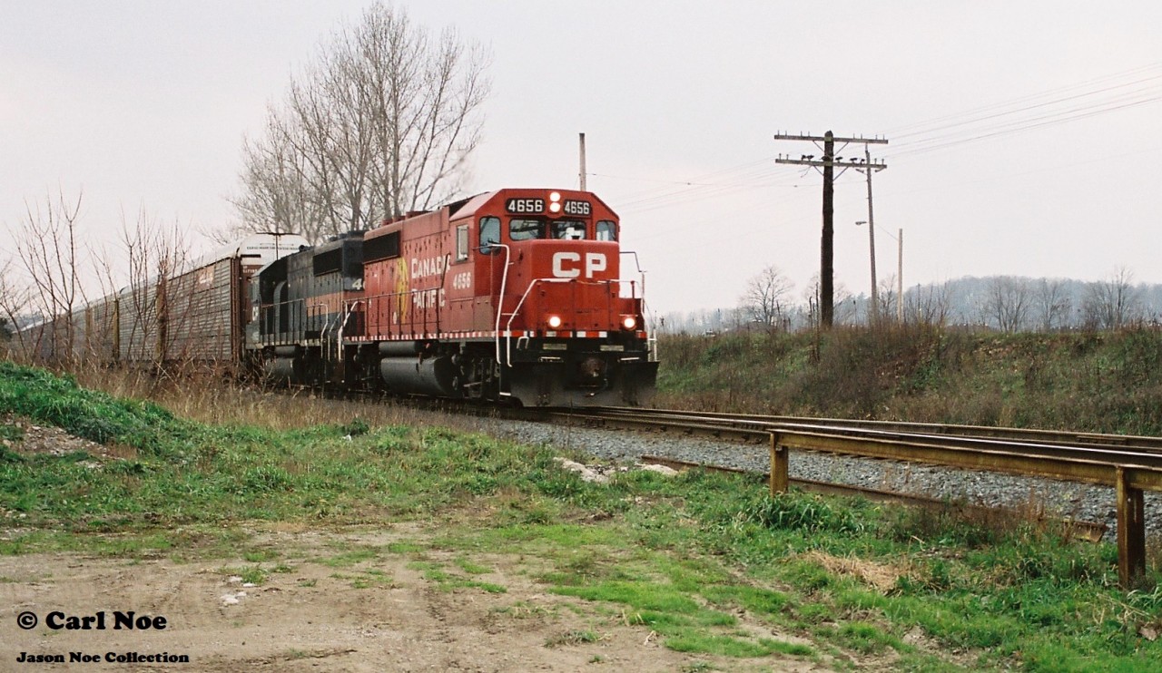 CP GP40-2 4656 and an ugly brother are viewed heading eastbound through the town of Ayr on the Galt Subdivision during an overcast fall day. This was likely either the London Pick-Up (T69) or the Hamilton Turn.