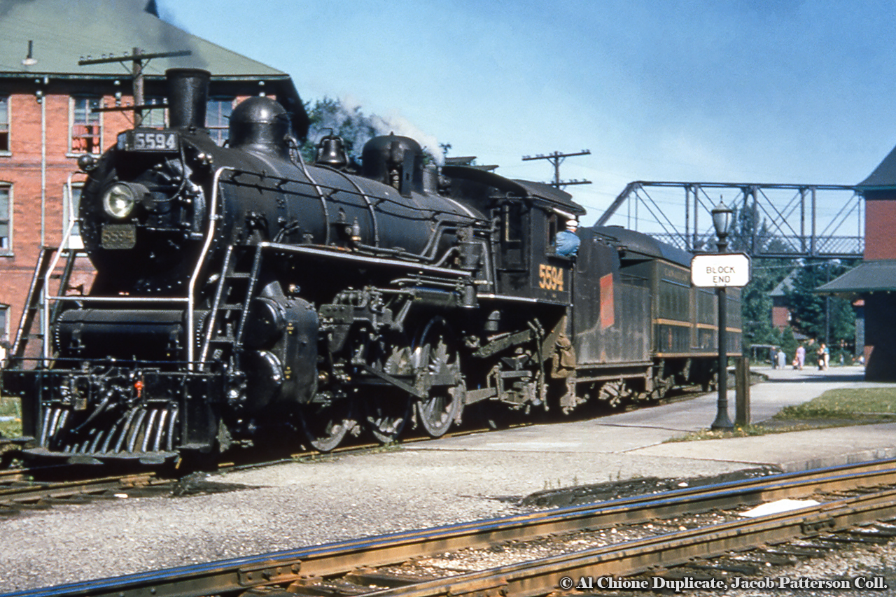 64 years ago as of this posting, CNR K-3-b Pacific 5594 shoves a baggage car along the Newton Subdivision side of the Palmerston station.  Lots of history to be seen in this shot, with the station at far right, the landmark iron bridge, and the now demolished Queen’s Hotel at left, readily available to travelers aboard the trains.  Original Photographer Unknown, Al Chione Duplicate, Jacob Patterson Collection Slide.