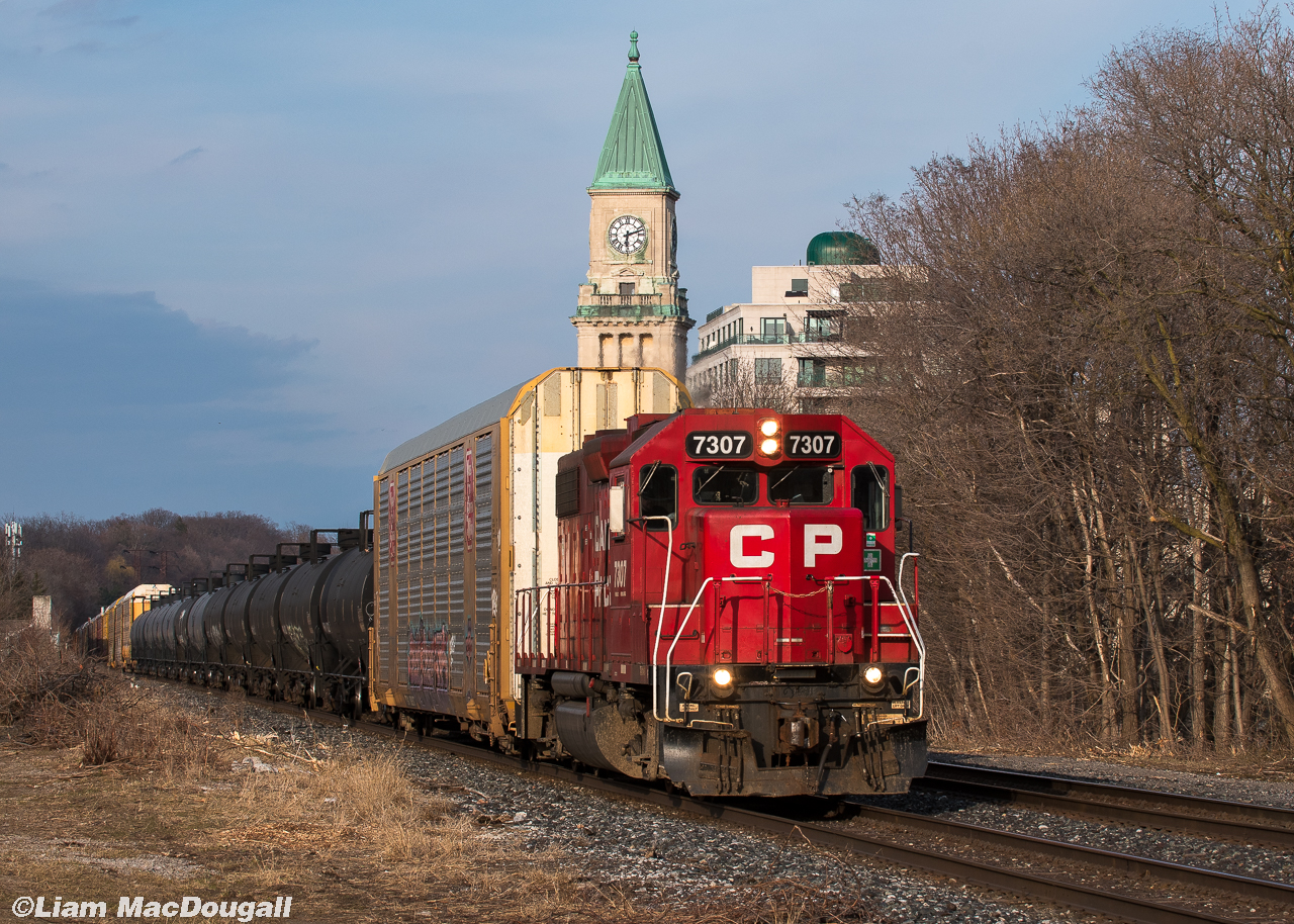 Sometimes, on rare occasions, being out on the North Toronto all day pays off. After the passage of 101, I noticed another westbound get lined out of Toronto Yard up to Davenport. Initially my thinking was that it would be the 2 GEs that had just come back from Oshawa, seeing as whichever power set is currently on the Oshawa turn also does the Spence turn. Even if it was the 2 mundane GE motors, I wasn’t gonna waste the evening light, so I posted up at Summerhill where I can frame a westbound nicely with the clock tower. Shortly after the train departed Kennedy I picked up some loose chatter over the scanner and was able to gather that they’d be making a run for Hornby. When ending the conversation with the RTC I was able to hear “7307 West, out.” nice and clearly. A few minutes pass and then around the bend comes 7307 solo in some sweet light as they haul both autoracks and tankers towards Hornby and eventually London.