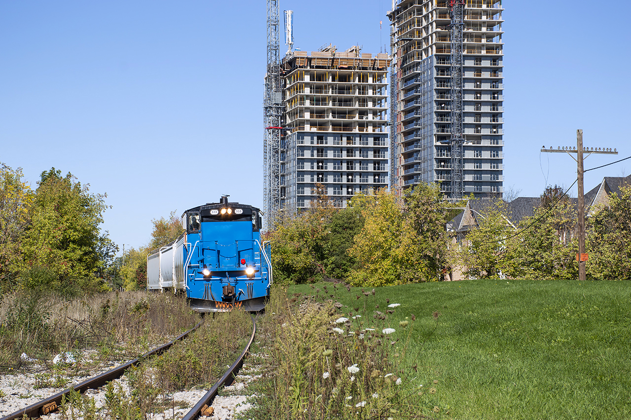 Facing the other direction from Dan's recent posting of the May 1, 1960 Triple Header, the future looms over the small twice-weekly freight dawdling through what is to become parkland in downtown Brampton.  Headed south, the Orangeville Brampton Railway approaches Queen Street, passing the former site of the CPR station.