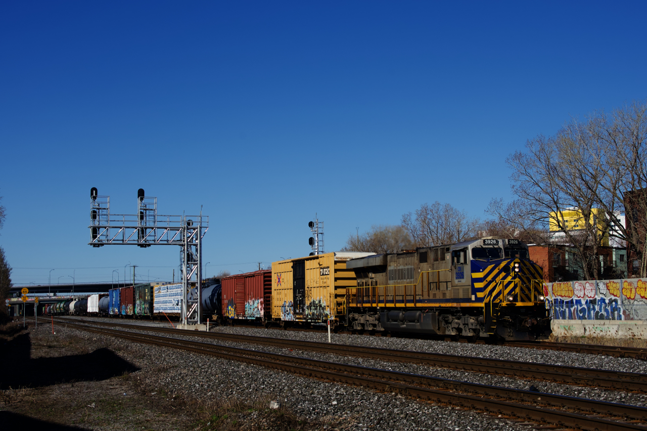 CN 310 has an ex-CREX unit up front, as well as another mid-train (CN 3926 & 3936) as it slowly heads east. Soon it will stop for awhile (blocking two crossings) as it sets off Joffre cars from its tail end onto the Freight Track. CN 310 had been replaced by CN 322 a couple of years back, but now CN 310 is back to running daily and CN 322 no longer runs.