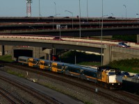 The last train of the day for Toronto is passing the Turcot Interchange with wrapped VIA 6416 and six LRC cars.