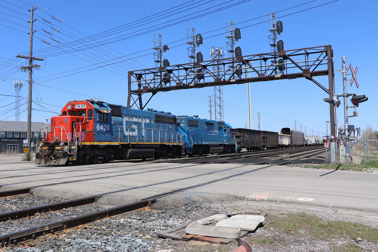 CN 554 backs across the Chartwell Road crossing while doubling its train prior to departure with 20 cars of general freight and 47 autoracks. Power today is GTW GP40-2 6420 (originally a DT&I unit) and CN GP38-2 4906 (the former GMTX 2273, previously LLPX 2244, originally built for the Long Island Railroad in 1976 as its 264).
CN 554 is normally ordered for 12:00 noon and typically departs about 90 minutes later.