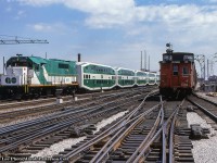 Saturday, April 29, 1978 saw GO Transit expand their operations north up the CN Bala Subdivision to Richmond Hill.  With F40 510 on the point and GP40TC 501 on the tail (presumed trailing since headlight is off), GO's inaugural trip is seen departing Union Station at Jarvis Street, passing the Crombie Park apartments public housing, under construction on the east side of Jarvis Street.  The train is made up of the <a href=http://www.railpictures.ca/?attachment_id=47324>new bilevel cars from Hawker Siddeley Canada,</a> the first ones having been unveiled only five months earlier in December 1977.  With stops at all stations between Union and Richmond Hill, an opening ceremony took place at each stop, ending with a meet between the new GO consist and CNR 6060 and CN coaches at Richmond Hill to contrast the old with the new.  See shots of that event in the Doug Page shots below.  At right, a CN freight heads eastbound just clearing the junction with the <a href=http://www.railpictures.ca/?attachment_id=21341>high line Union Station bypass.</a><br><br>Originally <a href=http://www.railpictures.ca/?attachment_id=32465>GO 601</a>, and later <a href=http://www.railpictures.ca/?attachment_id=48686>GO 9801</a>, GP40TC 501 would depart the GO roster in 1988 after 22 years of service, going to to <a href=http://www.rrpicturearchives.net/showPicture.aspx?id=1941379>Amtrak as 193,</a> and later rebuilt in 2005 as <a href=https://www.railpictures.net/photo/652853/>Amtrak GP38H-3 521.</a><br><br>More shots from the day:
<br><a href=http://www.railpictures.ca/?attachment_id=32148>6060 and GO 510 at Richmond Hill, by Doug Page</a>
<br><a href=http://www.railpictures.ca/?attachment_id=32150>ONR TEE-equipped Northlander passing 6060 amongst the crowds, by Doug Page</a><br><br>More Jarvis Street action:<br><a href=http://www.railpictures.ca/?attachment_id=48228>Inbound GO F40 meets freight by Arnold Mooney, 1977</a><br><a href=http://www.railpictures.ca/?attachment_id=47427>Eastbound freight by Peter Jobe, 1980</a><br><a href=http://www.railpictures.ca/?attachment_id=48674>VIA Turbo by Bruce Acheson, 1981</a><br><br><i>Bryce Lee Photo, Jacob Patterson Collection slide.</i>
