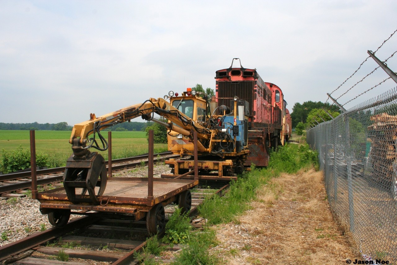 Ontario Southland Railway (OSRX) 506 and OSRX L3 along with a former CP Rail baggage car and some track equipment are viewed during a summer afternoon in the sleepy village of Mount Elgin on the former CP Port Burwell Subdivision.