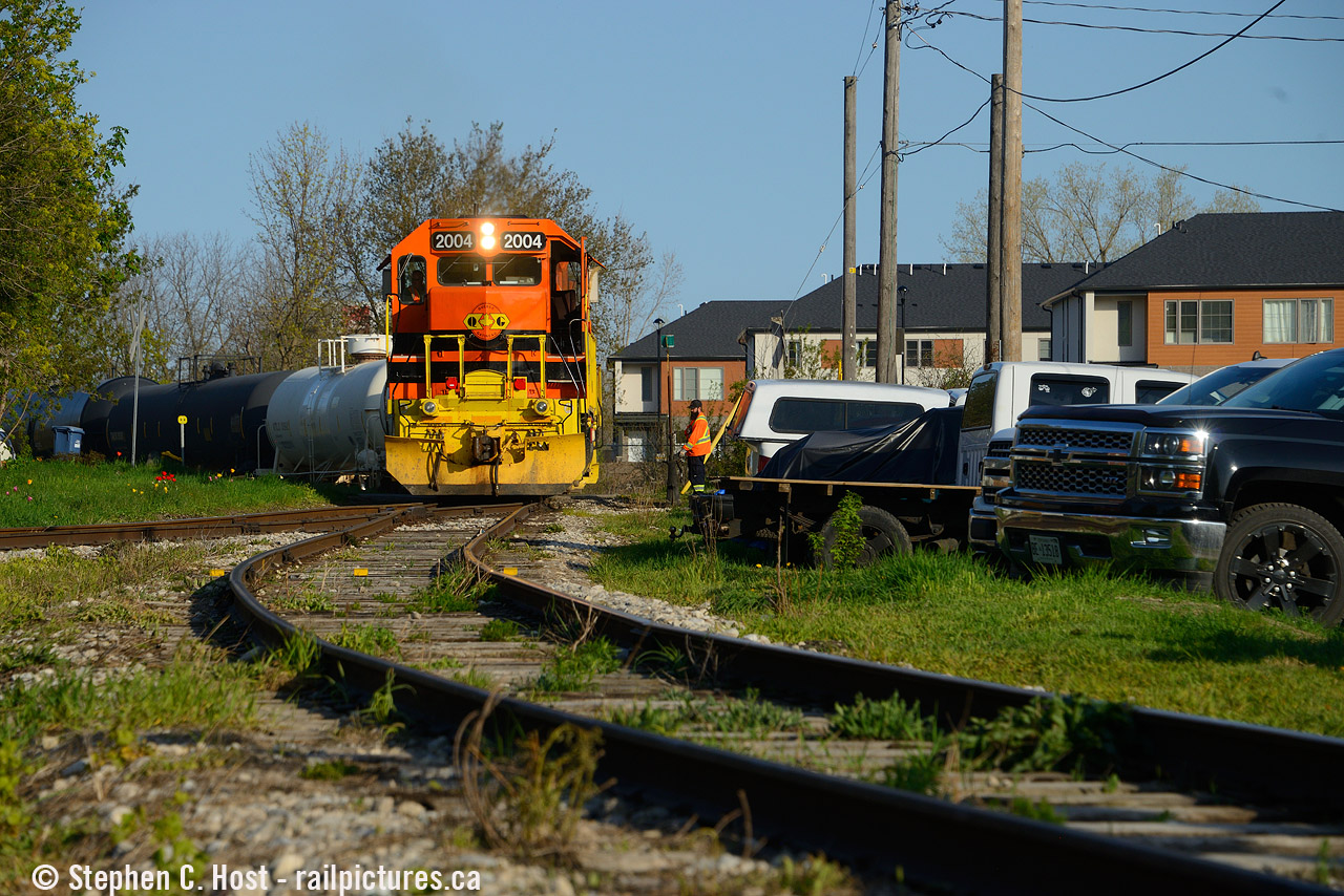 With a half dozen cars in tow, GEXR 583 has finished rounding the wye along Sackville St in Guelph, and will soon head on the south leg of the wye to head to the next customer.  Nearby is the ever present "northern rubber" factory where  signs of local industrialist James Walter Lyon's vision of development remain (Build industries, and housing nearby for workers - something we frown upon now).  An interesting mashup, houses and the railway right beside each other harkening back to a different time when folks didn't have cars and workers walked to work in nearby factories. Now, the folks just park on railway property with full city permission (it's signed!) This would have probably been one of Guelph's poorest neighbourhoods and kind of still is, but there are signs of gentrification all around as many of the pretty beat up looking  homes are being fixed up as well as the factories are currently turning to Condos in a flurry of construction. For now, the dichotomy between railway and housing continues and is worth a visit to see for yourself.