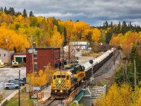 Under brooding autumn skies — that, in retrospect, may have been foreshadowing what was to come — a pair of Ontario Northland EMD SD40-2s hustle Timmins to Englehart train no. 308 past the line-side sentinels at Swastika, Ontario. 

Unbeknownst to the photographer, less than 6 months after this photo was taken, the unique 1967-constructed station and surrounding signals would be reduced to a heap of rubble. 

With the demolition of the town's station, Swastika not only lost a piece of its railroading heritage but a sense of character. All too often, the railroad landscape of today seems to become more and more sterile as the aesthetic of place is drowned out by ubiquity. An unexpected demolition such as this illustrates the point and serves as a reminder that in railroading, the only constant is change.