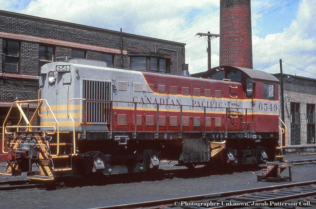 CPR S3 6549 sits at Lambton roundhouse outside the motive power office building (note bay window), which housed the “General Locomotive Foreman, the Shop Foreman, Boiler Foreman, the crew clerks,” and various other positions.  It also contained a booking-in room for engine crews.  The smokestack at right is attached to the boiler room off the machine shop.  Building info per Ray Kennedy.Original Photographer Unknown, Jacob Patterson Collection Slide.