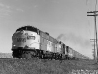 Less than a year after the VIA takeover and being rerouted from <a href=http://www.railpictures.ca/?attachment_id=42540><b>CP's MacTier Subdivision</b></a> to CN's Newmarket Sub, VIA #1 "The Canadian" throttles up as it hammers the diamond at CN Snider on its way north out of Toronto, passing through <a href=http://www.railpictures.ca/?attachment_id=8883><b>Concord</b></a> (Vaughan) at the northern edge of the city.<br><br>Leading is VIA FP7 1416, a recently repainted ex-CP unit (also equipped with new nose MU connections around the same time, something CP units never had). Assisting is CP GP9 8517, one of the steam-generator equipped dual-service GP9's that CP kept as passenger protection power. It was uncommon to see GP9's run through this far east of Winnipeg during the CP Canadian era, but it became more commonplace by the time VIA came on the scene as CP had recently retired a lot of its steam generator equipped MLW fleet (all of the 4090-series FPA2's and a bunch of of the SG-equipped RS10's were retired, many of which had held down a lot of the Toronto-Sudbury Canadian runs. And the 4070-4075 FP7 group eluded sale to VIA, were kept and sent out east for Montreal commuter service). On the flip side, it also became more common to see the remaining CP RS10's straying out west on VIA's Canadian.<br><br>Passenger equipment in the trailing consist now includes a VIA-painted ex-CN steam generator car, and some VIA (ex-CN) passenger equipment mixed in with the stainless steel Budd cars that still bear their action red paint and CP Rail lettering.<br><br><i>David M. More photo, Dan Dell'Unto collection print.</i>